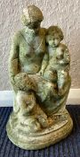 A classical stone garden statue depicting woman with two infants.