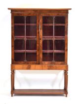 A Victorian mahogany display cabinet, the two glazed doors enclosing three velvet-covered shelves,