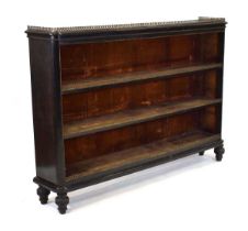 An Aesthetic Movement ebonised open-fronted bookcase with a brass fretwork gallery and mounts, two