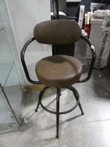 Black metal framed swivel stool in a brown upholstered leatherette finish