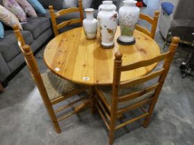 Small circular pine kitchen table with 4 matching rush seater leather backed dining chairs