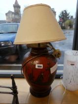 Oriental red and gilt patterned table lamp with cream shade