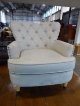 Modern off white button backed upholstered and brass studded easy chair