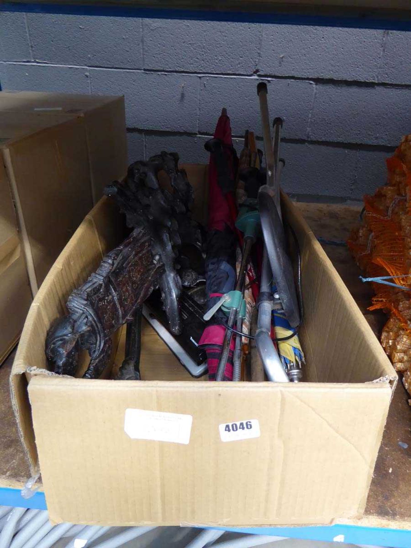 Box containing quantity of umbrellas, small fold-up chair, lamp and wooden statue