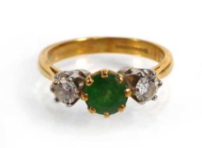 An 18ct yellow gold ring set brilliant cut emerald and two diamonds in an inline setting, Birmingham
