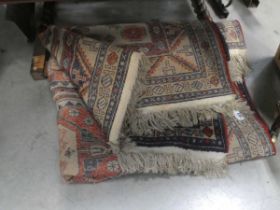 A mid-to-late 20th century woollen rug, the cream ground with three medallions within matching bands