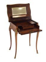 A French ladies dressing table, the walnut and brass mounted surface lifting to reveal a mirrored
