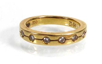 An 18ct yellow gold band ring set seven small diamonds in recessed settings, ring size F, 2.8 gms