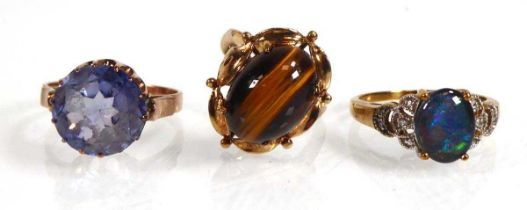 A 9ct yellow gold ring set cabochon tigers eye and two further yellow metal dress rings, various