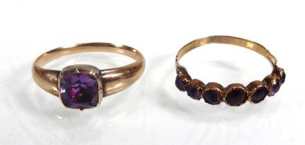 A yellow metal ring set seven graduated amethyst in an inline setting, ring size O 1/2 and a further