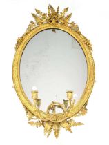 A 19th century giltwood and plaster wall mirror, the oval plate surrounded by relief flowers and