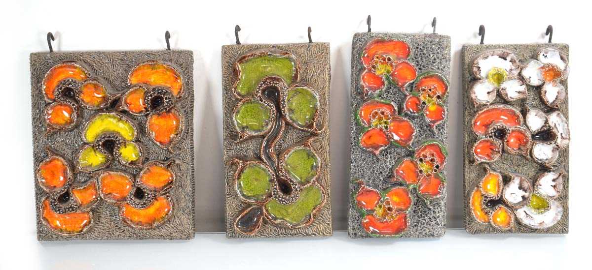 A set of four 1960's Dutch ceramic wall-hung plaques decorated with bright flowers, by Jan Van