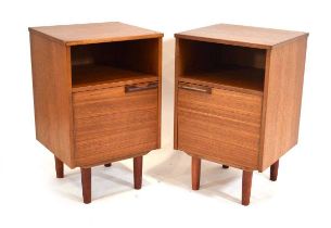 A pair of 1970's teak bedside cabinet, each with a single door, moulded handle and later tapering