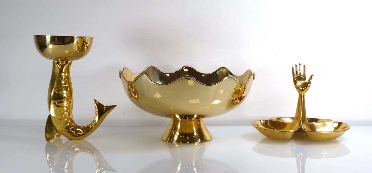 A Jonathan Adler brass finished ring holder modelled as a hand together with a matching footed