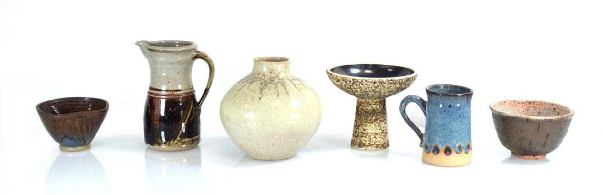 A group of six British studio pottery pieces including a jug by Richard Cheshire, a vase by A. Hardy