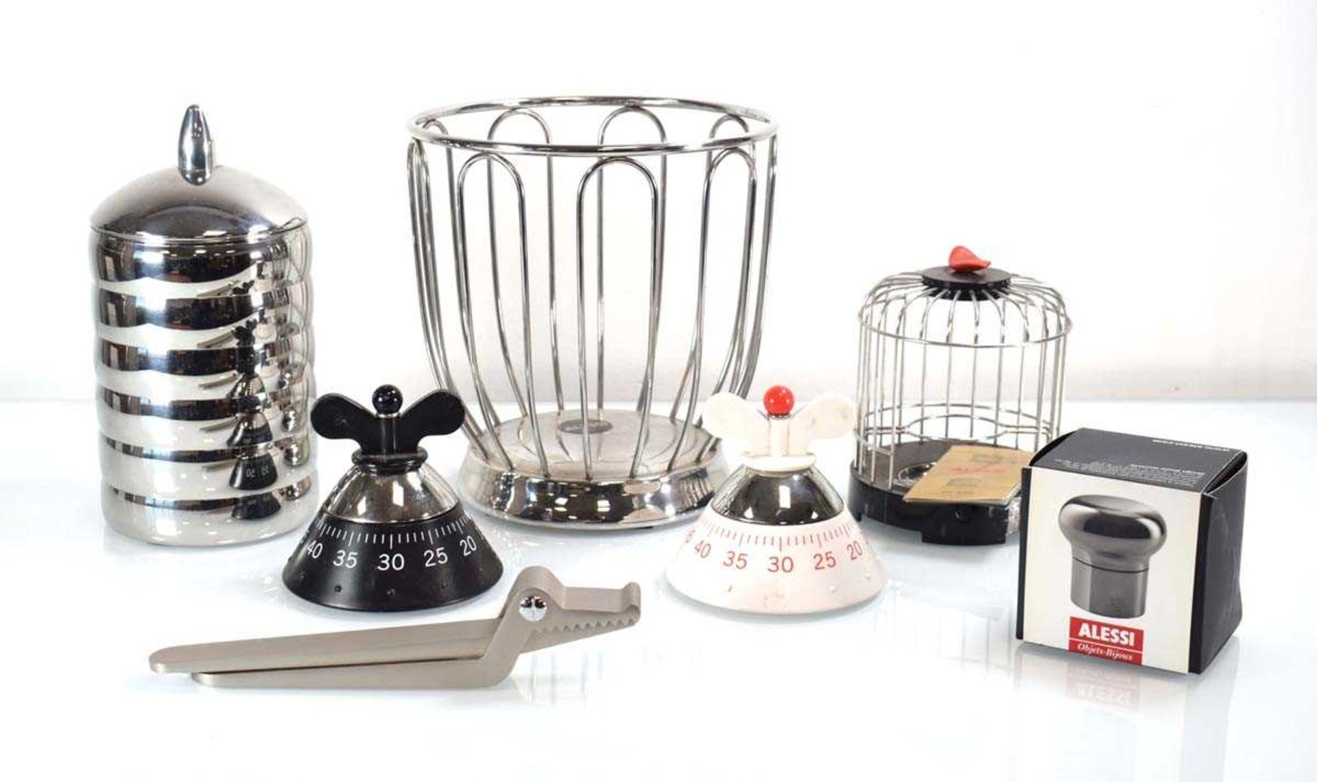 A group of Alessi kitchen items including two timers, a 'Sweetheart' crocodile nutcracker, a '
