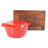 A Danish red enamelled casserole dish and cover by Nacco, di. 29 cm, together with a teak cooling