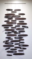 A contemporary Italian wall hanging with black ash 'pebbles', labelled 'Inartemvertere by I. & S.