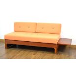 A 1960/70's teak daybed, the orange button-upholstered seat with two loose back cushions, the side