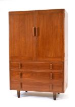 A 1950/60's solid teak dressing cabinet with two doors, two drawers and chunky handles, on later