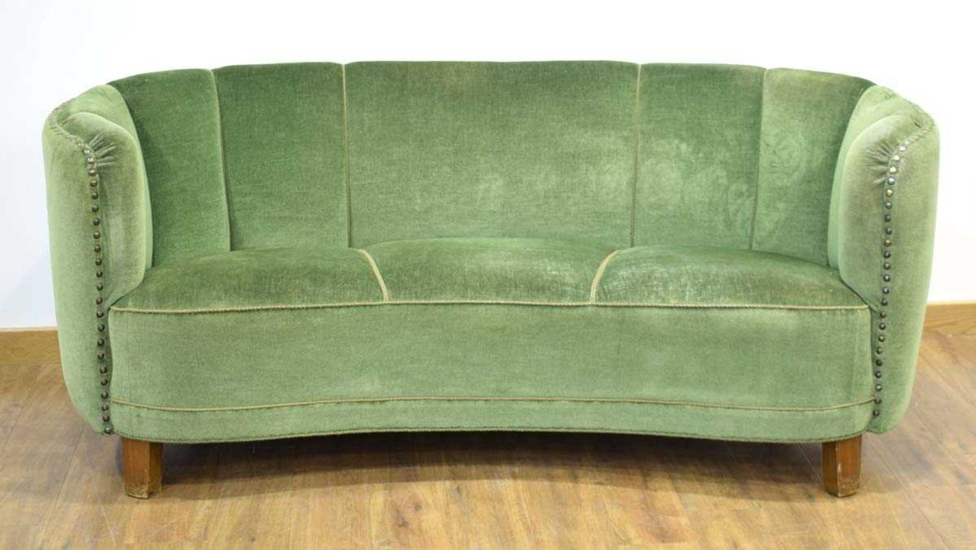 A 1940/50's Danish 'Banana' sofa upholstered in green on mahogany block feet *Sold subject to our