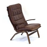 In the manner of Ingmar Relling, a 1960's Danish lounge armchair with a laminate frame and brown