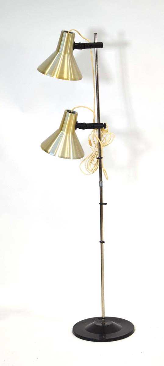 A 1970's Danish brass-finished twin-spot floor lamp on a black circular base Lead cut, working order