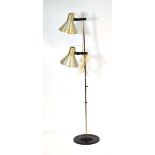 A 1970's Danish brass-finished twin-spot floor lamp on a black circular base Lead cut, working order