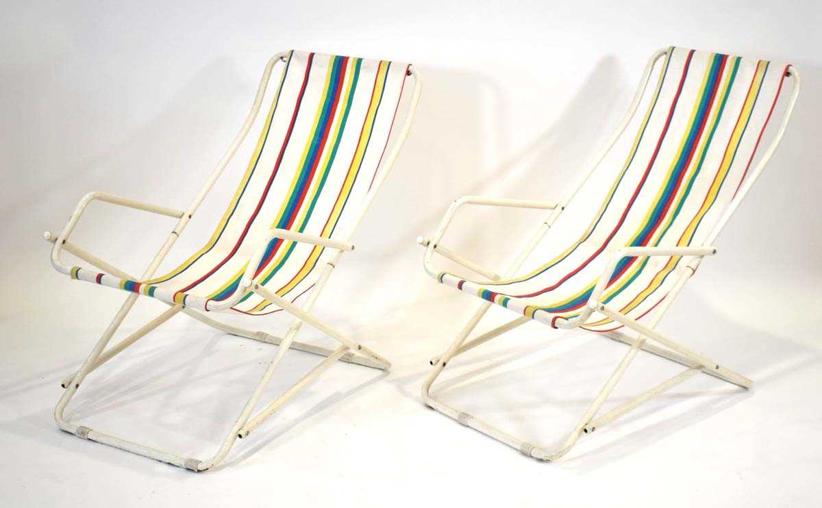 A pair of Grand Soliel deckchairs with white tubular frames and stripped seats