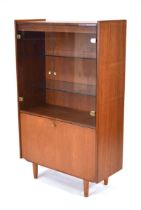 A 1970's teak cabinet, the two glazed doors with brass-finished handles, over a fall-front, on