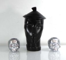 Attributed to Lindsey B, a 'Peking' jar in black together with a pair of Kosta Boda votive skulls (