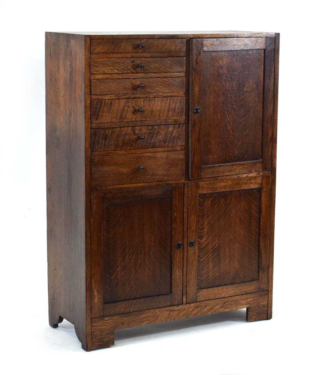 A 1930's oak dentist's cabinet with an arrangement of doors and drawers, 77 x 32 x 106 cm *A similar