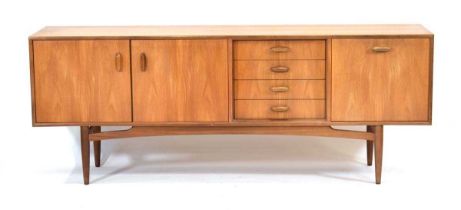 A 1960's G-Plan teak sideboard with a pair of doors, four drawers and a fall-front door, on tapering