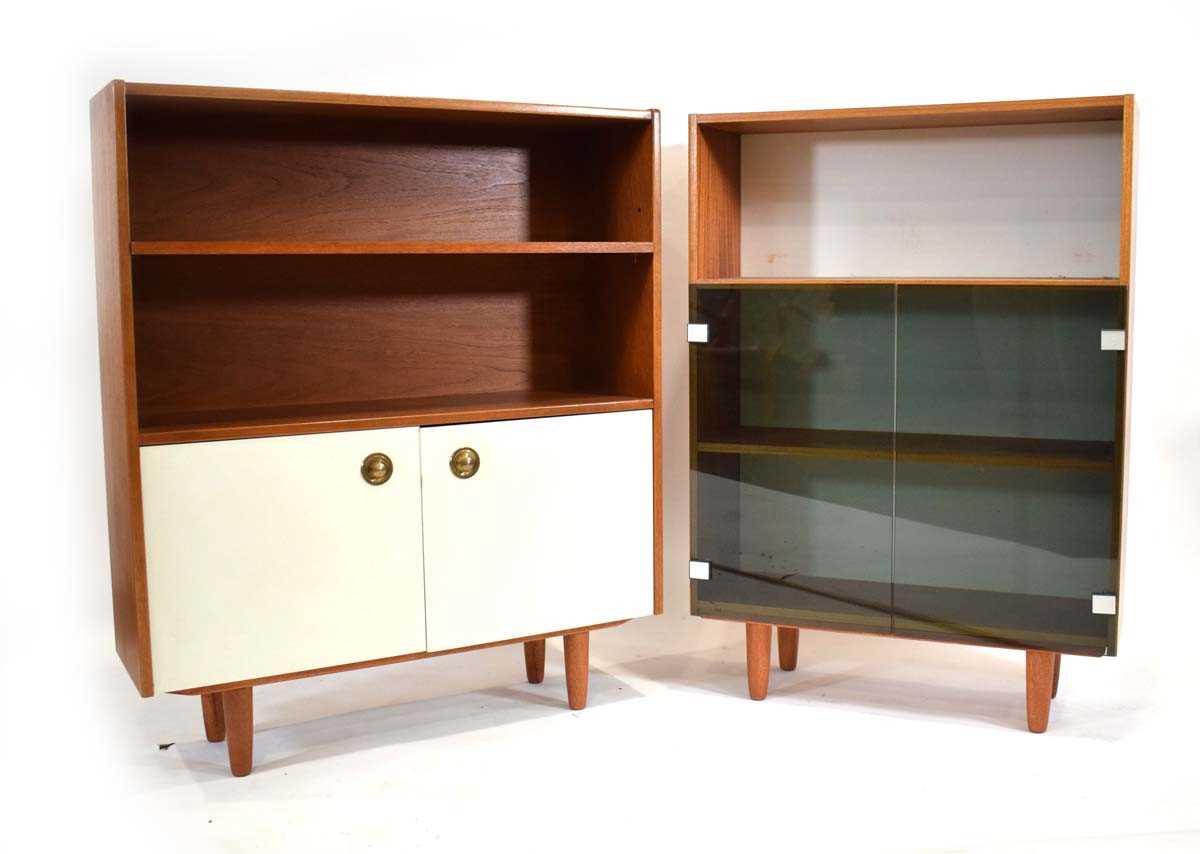 A 1970's teak cabinet with two smoked glass doors, together with a similar bookcase with two white