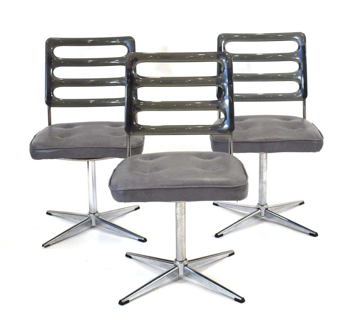 A set of three 1970's Chromcraft dining chairs with smoked perspex backs over grey seats on four-