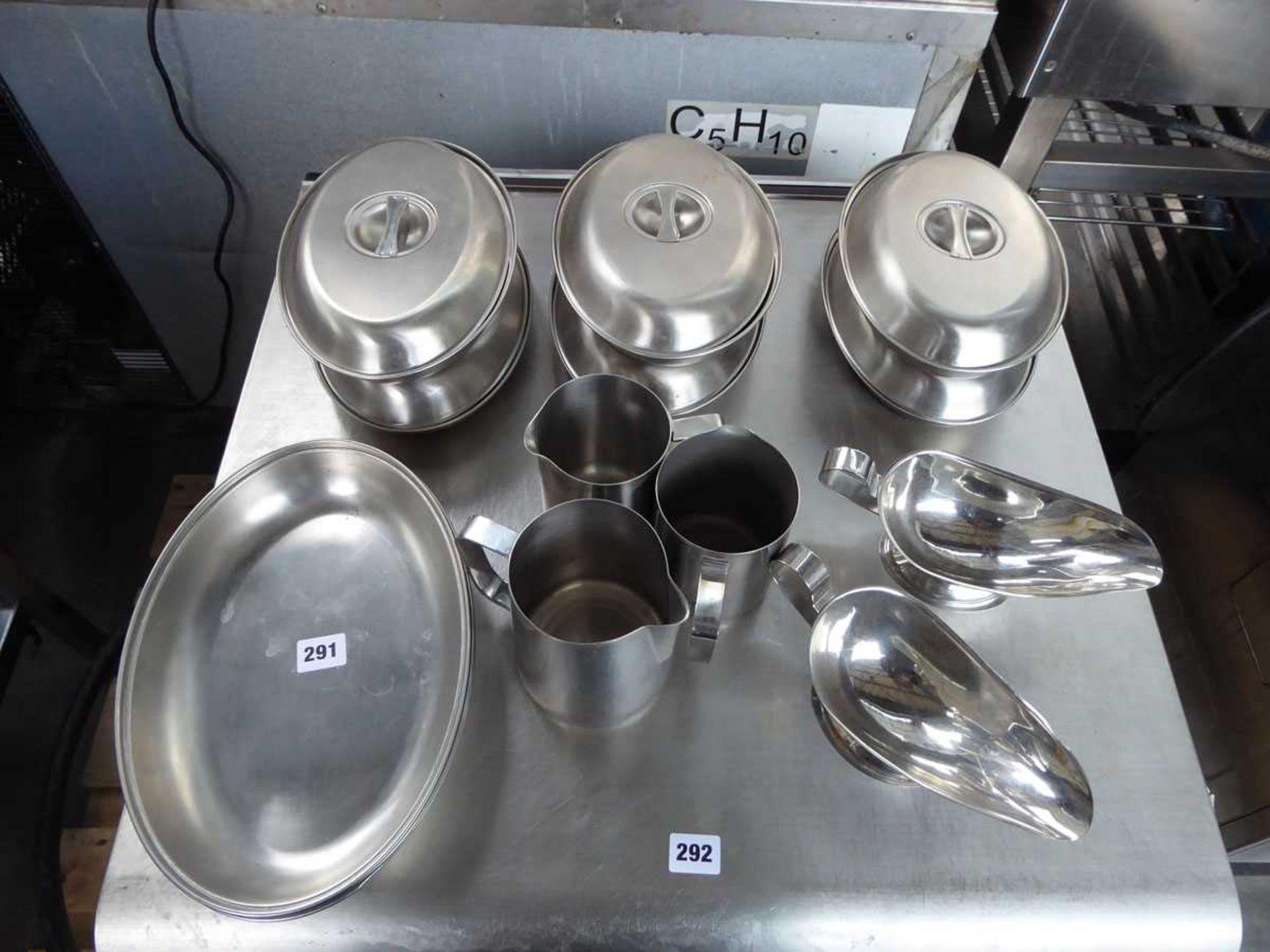 Table top of assorted stainless steel oval dishes, some with lids, gravies and creamers