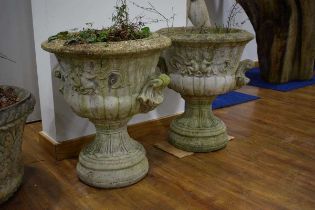 A pair of concrete garden planters of urn form relief decorated with cherubs and swags, di. 57 cm,