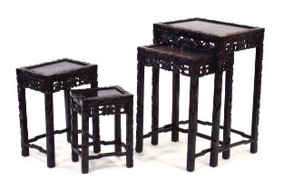 A nest of four Chinese Export occasional tables with foliate carved edges, matching fretwork