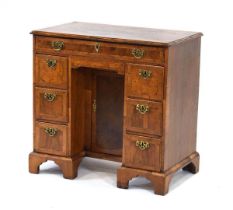 A George III walnut, feather banded and crossbanded kneehole desk with eight drawers and a