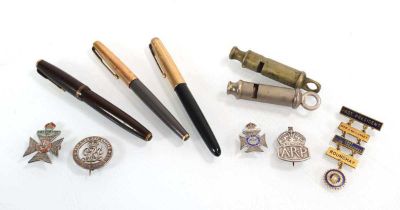 A small group of collectables including a Parker pen with a 14ct gold nib, four silver badges, a