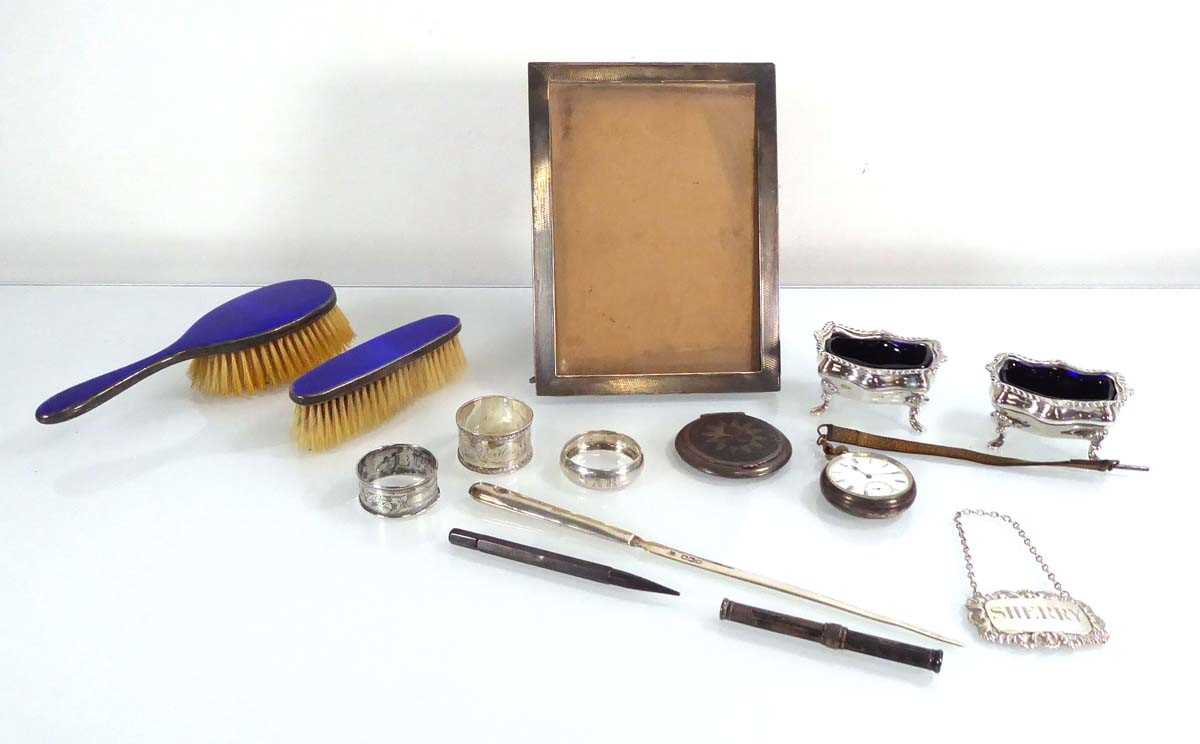 A mixed group of silver comprising a photograph frame, a pair of salts, two hairbrushes, three