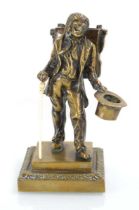 A 19th century bronze match holder modelled as a travelled with a knapsack and top hat holding a