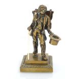 A 19th century bronze match holder modelled as a travelled with a knapsack and top hat holding a