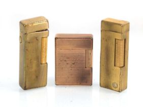 A group of three gilt metal lighters by Dupont and Dunhill (3)