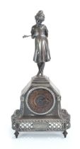 An early 20th century mantle timepiece, the pewter case surmounted by a gilt over Arabic numerals,