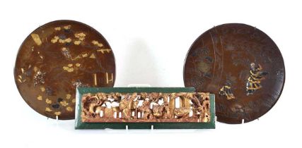 A pair of brown patinated Japanese wall plates relief decorated with silvered and gilt figures,