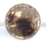 A mid-20th century silver salver of circular form on three claw and ball feet, Mappin & Webb,