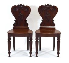 A pair of Victorian mahogany armorial hall chairs