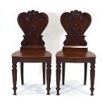 A pair of Victorian mahogany armorial hall chairs