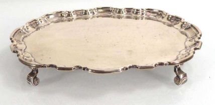 A small silver salver of oval form on four scrolled feet, maker HA, Sheffield 1963, w. 23 cm, 11.4